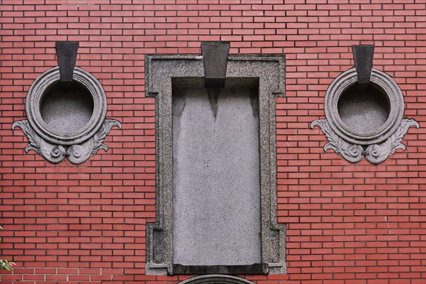 兩扇有毛莨葉裝飾的對稱牛眼窗，因此設計像方便供電報線出入，被推測當初此建築原為「清代電報學堂」所建。